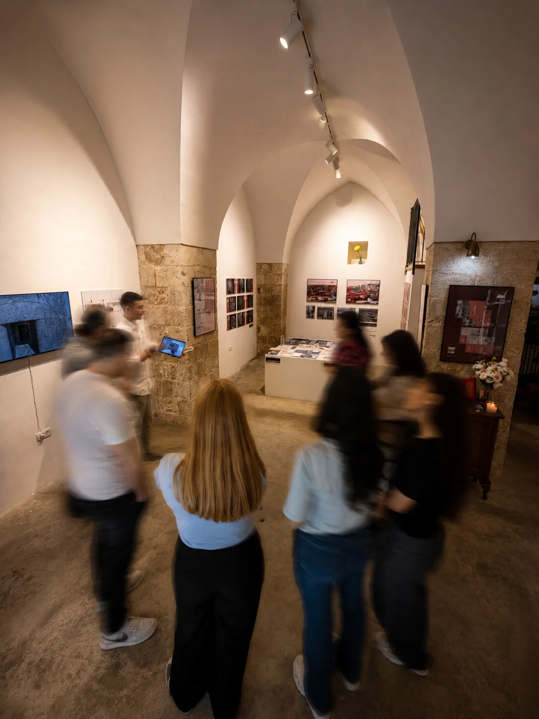 Visitors gathered in the vaulted gallery during an exhibition walkthrough