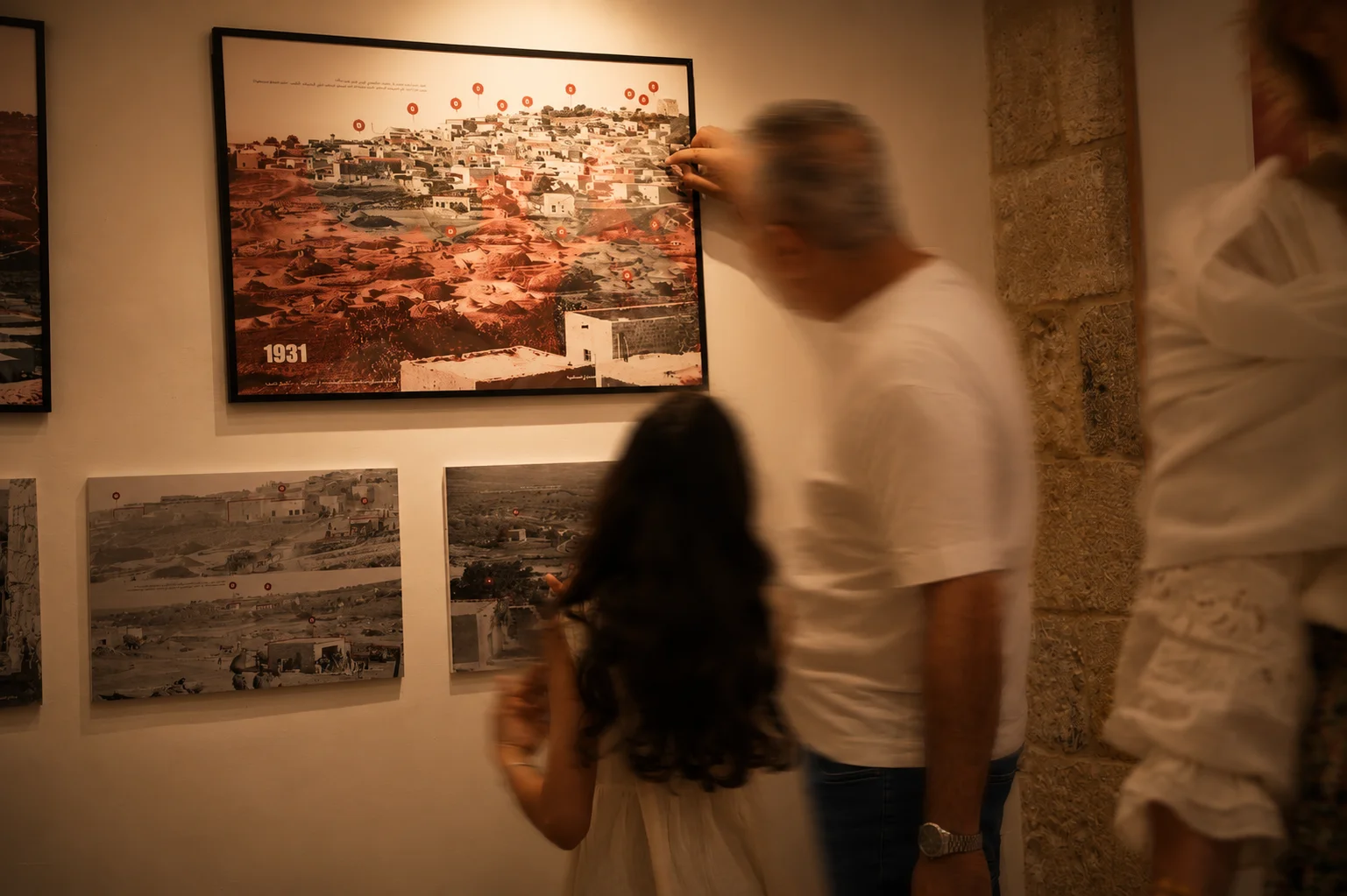 Visitors examining a 1931 archival panorama of Saffuriya