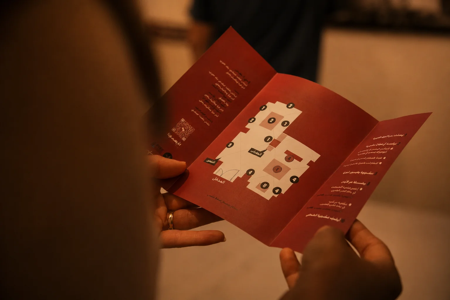 Visitor holding the printed exhibition map brochure